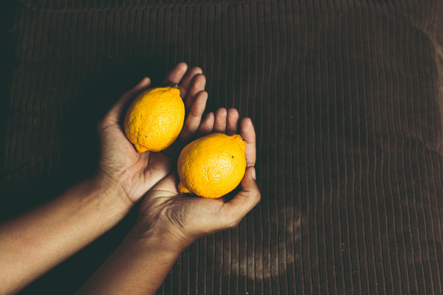 Bright yellow lemons arranged on a pastel background, symbolizing the fresh and inviting approach to exploring pleasure.