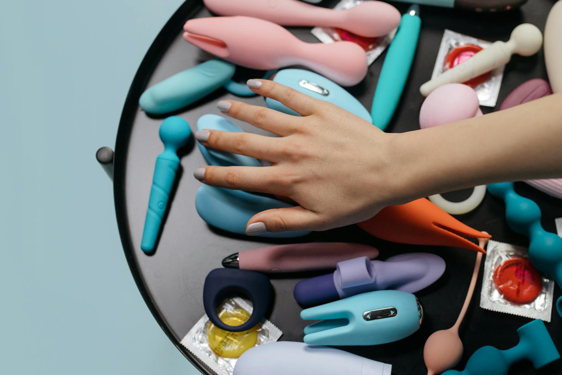 A close-up of a hand holding a vibrator against a minimalistic backdrop, showcasing sensation and self-pleasure.