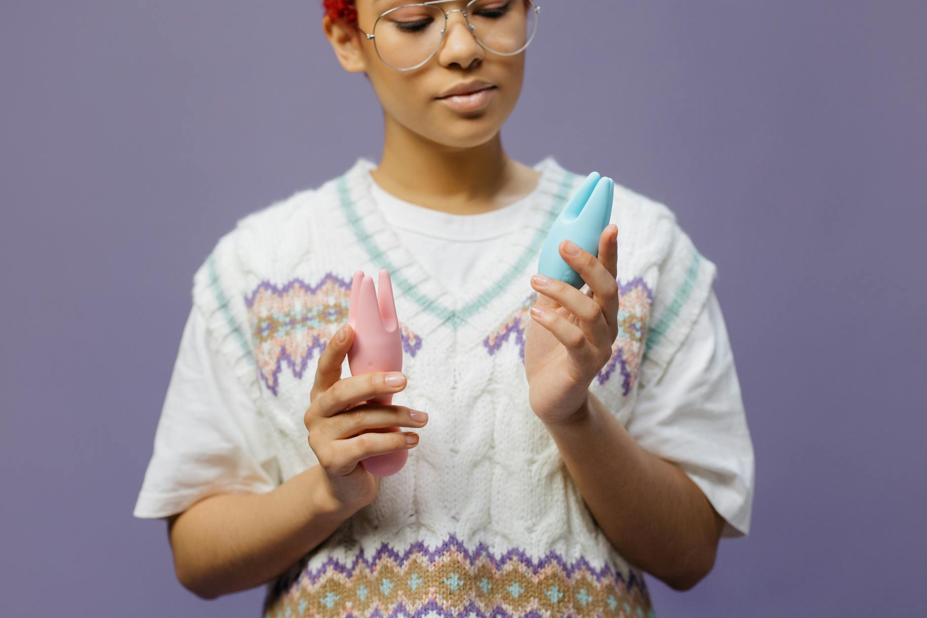 Woman holding colorful vibrators while exploring pleasure and sensation recovery options