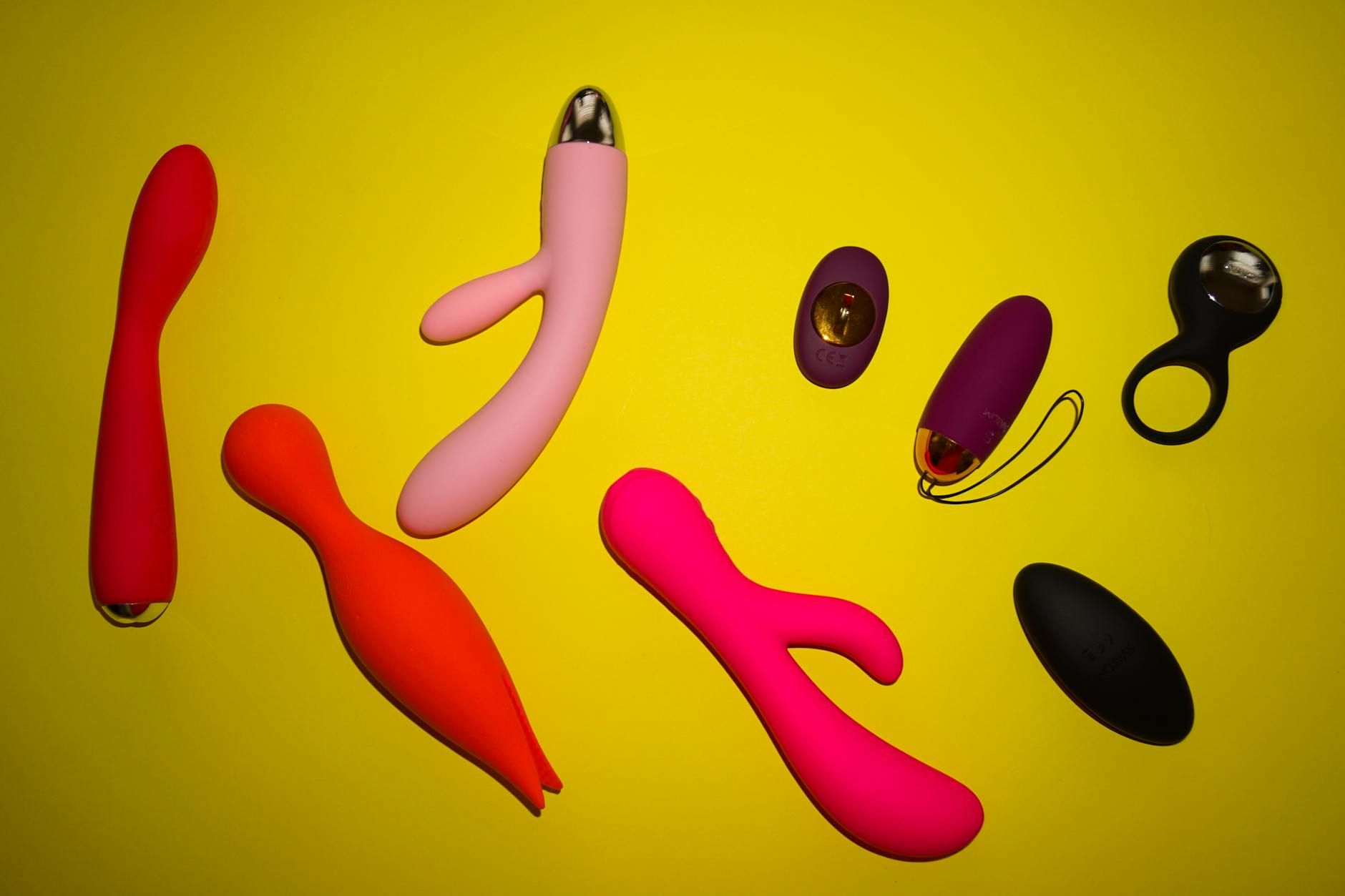 Close-up of a hand holding a vibrator against a minimalist purple backdrop
