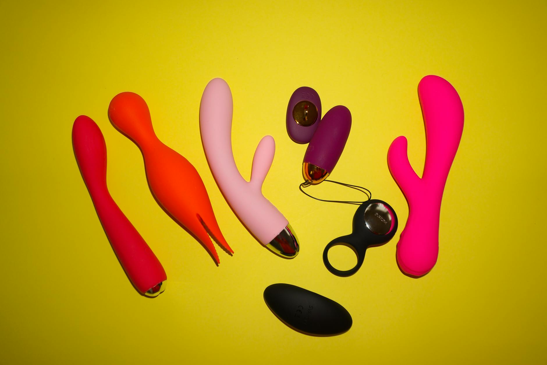A sleek teal vibrator resting on soft white silk fabric, symbolizing gentle intimate wellness